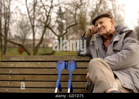 Un homme âgé, senior, 92, sur un banc avec des béquilles Banque D'Images