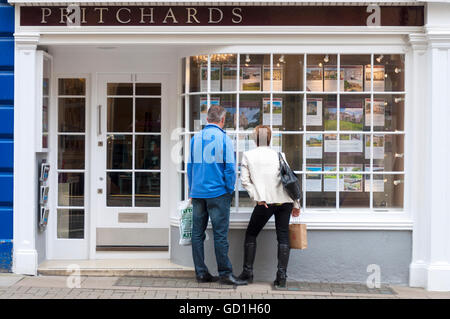 Couple à la fenêtre de l'agent immobilier à Pritchards à Bath, Somerset, Royaume-Uni. Banque D'Images