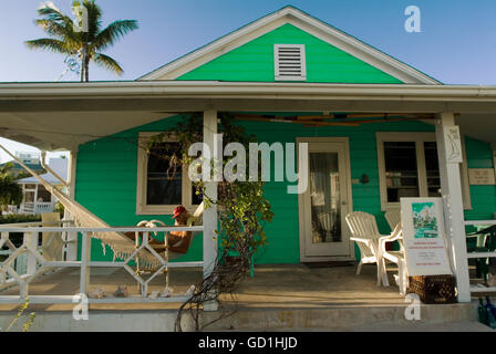 Maison loyaliste typique, l'espoir, la ville de Nassau, Cay Elbow. Bahamas. Se détendre dans un hamac. Banque D'Images