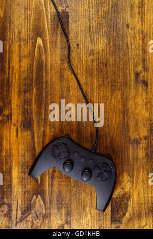 Contrôleur de manette de jeu sur un bureau en bois, télévision jeter dessus, jeux et divertissement concept with copy space Banque D'Images