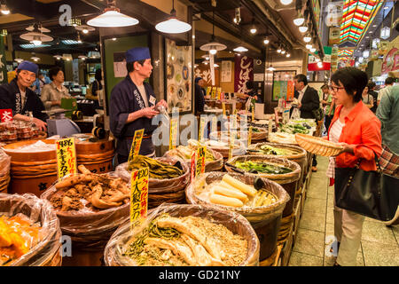 Avec panier d'achat de l'acheteur considère au niveau local food, Japonais Nishiki Market, le centre-ville de Kyoto, Japon, Asie Banque D'Images