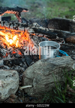 Faire le café sur feu de bois dans la forêt. Banque D'Images