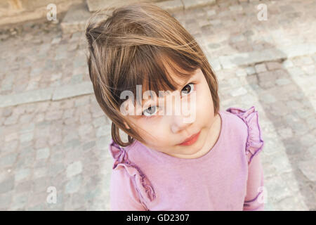 Portrait en extérieur gros plan de funny cute Caucasian blonde petite fille en rose Banque D'Images