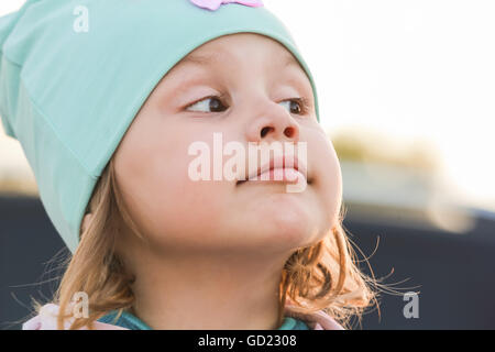 Libre face portrait de funny cute Young blond bébé girl in green hat Banque D'Images