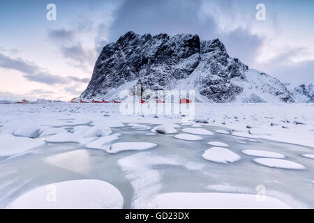 Des sommets enneigés et des maisons de pêcheurs typiques de la trame appelé Rorbu, Eggum, Île Vestvagoy, îles Lofoten, Norvège Banque D'Images