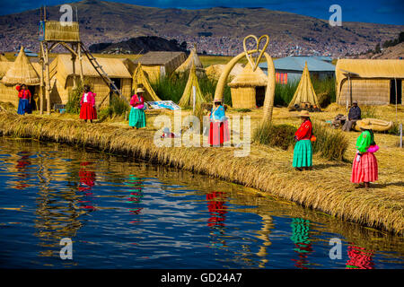 Famille d'Indiens Quechua sur les îles flottantes des Uros, herbe du Lac Titicaca, le Pérou, Amérique du Sud Banque D'Images