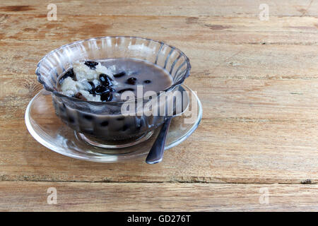 Le Riz collant doux et haricots noirs dans le lait de coco. Dessert thaïlandais sur table en bois Banque D'Images