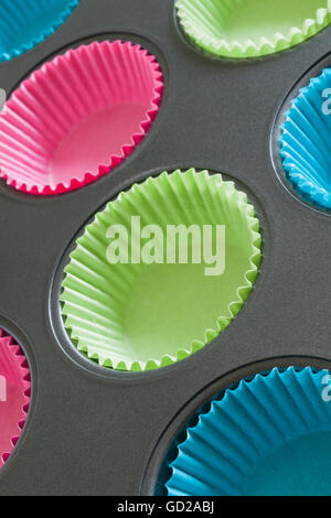 Cake ou muffin tin avec du papier coloré cas utile pour les concepts de cuisson Banque D'Images