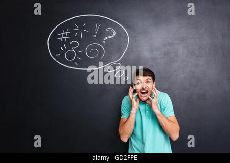 Fou furieux young man standing et hurler sur tableau noir avec bulle d'arrière-plan Banque D'Images