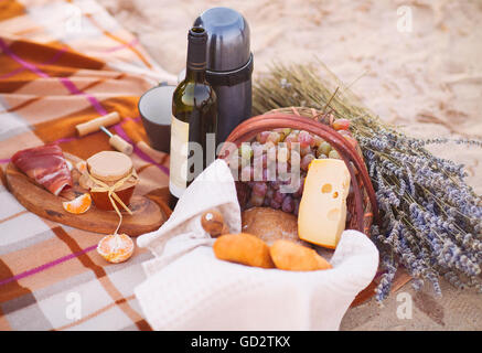 Pique-nique d'automne par la mer avec du vin, raisins, pain, confiture et fromage Banque D'Images