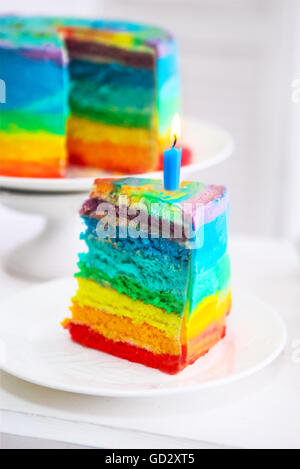 Gâteau arc-en-ciel décoré de bougie d'anniversaire. Close up Banque D'Images
