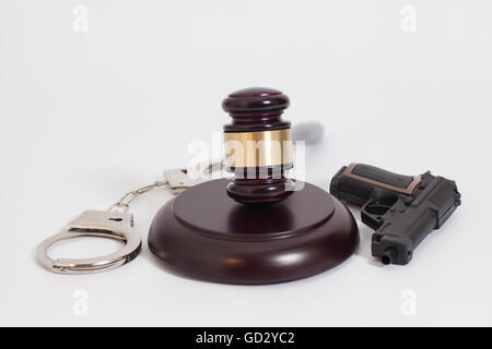 Judge's gavel, pistolet et menottes sur fond blanc Banque D'Images