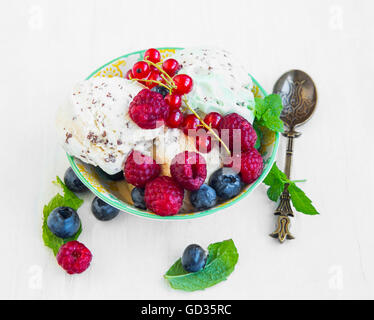 La vanille fraîche icecream avec copeaux de chocolat avec des framboises, groseilles rouges et les bleuets et de feuilles de menthe Banque D'Images