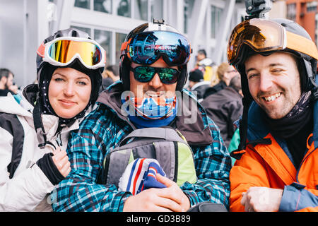 Trois personnes, une jeune femme et deux hommes de ski (2006), dans une rangée sur un ski vacances. Banque D'Images