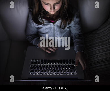 Petite fille, assise dans un endroit sombre, jouant avec coffre Banque D'Images