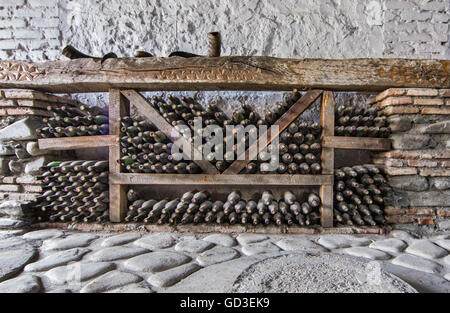 Vieilles bouteilles de vin dans une cave à vin en Géorgie avec un vin kvevri pot en argile en face Banque D'Images