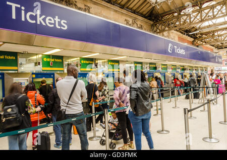 Les gens de la file d'acheter des billets de train au guichet dans la gare de Victoria, Londres. Banque D'Images