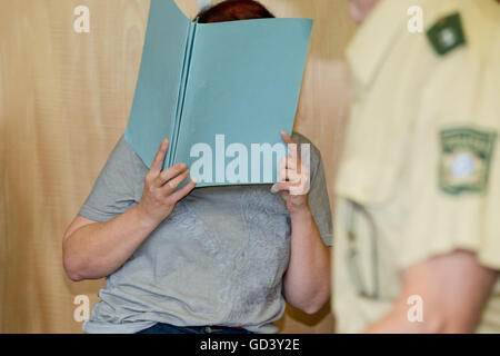 Coburg, Allemagne. 12 juillet, 2016. Défendeur Andrea G., qui est accusé de meurtre, couvrant son visage avec un dossier, dans la salle d'audience de la cour régionale de Coburg, Allemagne, 12 juillet 2016. Après 8 de ses bébés ont été trouvé mort à son domicile, le procureur a accusé Andrea G. de tuer délibérément 4 d'entre eux. Leur père est accusé d'aider son épouse. PHOTO : DANIEL KARMANN/DPA/Alamy Live News Banque D'Images