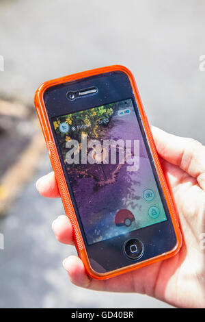 Une jeune personne utilise un iPhone pour jouer à Pokémon sur rendez-vous, le dernier jeu de réalité augmentée mobile app pour frapper le marché des applications dans le monde entier. Banque D'Images