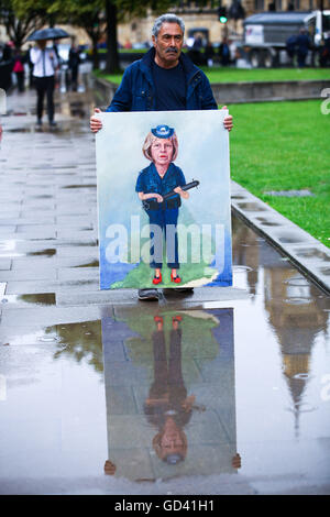 Londres, Royaume-Uni. 12 juillet, 2016. UK Météo : pluie torrentielle au Collège Green. Une réflexion de la peinture de l'artiste Kaya Mar de Theresa peut comme agent de police avec un crédit club cloué : Dinendra Haria/Alamy Live News Banque D'Images