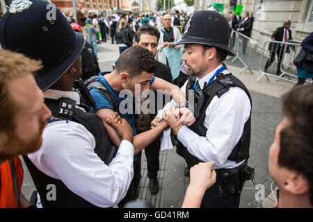 Londres, Royaume-Uni. 11 juillet, 2016. Militant des droits de l'homme bahreïni Alaali Isa souligne que les menottes ont été obtenus de façon trop serrée après leur arrestation lors d'une manifestation devant une réception officielle pour le Farnborough International foire aux armements assisté par les marchands d'armes au Musée des sciences. Certains marchands d'armes, de participer à la réception sont soupçonnés d'avoir été refoulé à la suite de la manifestation organisée par la campagne contre le commerce des armes. Les manifestants s'opposent en particulier à la vente d'armes à l'Arabie saoudite, utilisé dans des violations des droits de l'encontre de la population yéménite. Credit : Mark Kerrison/Alamy Vivre sw Banque D'Images