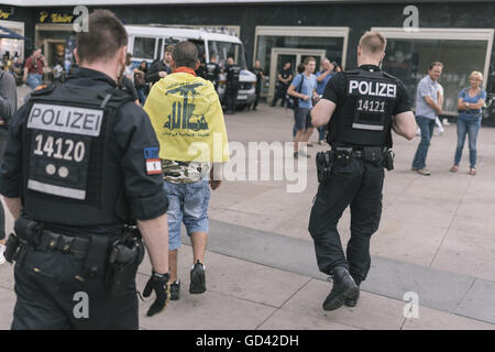 Berlin, Berlin, Allemagne. 12 juillet, 2016. Un manifestant portant un drapeau du Hezbollah au cours de la lutte contre Israël manifestations organisées par Martin Lejeune à Berlin qui a eu lieu sous la devise '10. Israelischer Jahrestag Angriff auf Liban und sein Volk ! [10e anniversaire de l'attaque israélienne sur le Liban et son peuple ! Crédit : Jan Scheunert/ZUMA/Alamy Fil Live News Banque D'Images