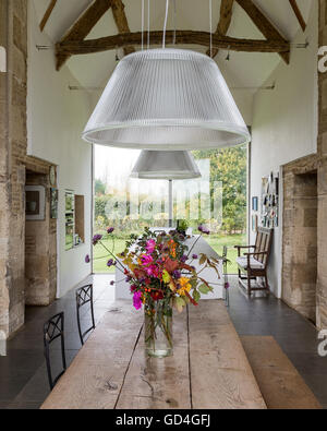 Plafond avec poutres en bois au-dessus de table style réfectoire en double-hauteur grange convertie Banque D'Images