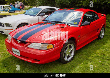 Une Ford Mustang rouge, exposé dans un champ à un rallye de voitures anciennes à Llancaiach Fawr Manor, Pays de Galles, Royaume-Uni Banque D'Images