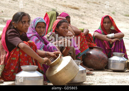 Femme assise avec un pot d'eau Banque D'Images