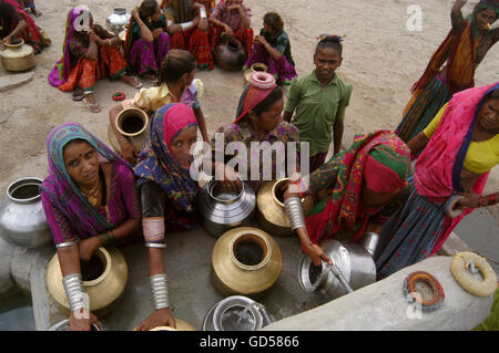 Femme assise avec un pot d'eau Banque D'Images