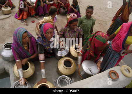 Femme assise avec un pot d'eau Banque D'Images