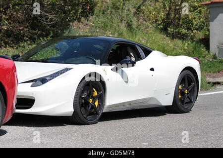 Ferrari blanc avec roues Noire stationnée sur le côté de la route en Toscane, Italie sur une journée ensoleillée Banque D'Images