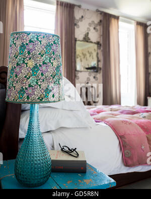 Lampe moderniste avec chintzy ombre sur lit table Banque D'Images