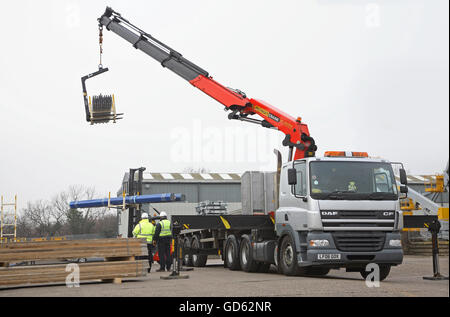 Une grue Hiab montée sur cabine et d'un chariot élévateur sont utilisés pour décharger les produits de bâtiment en acier dans une démonstration de sécurité du chargement Banque D'Images