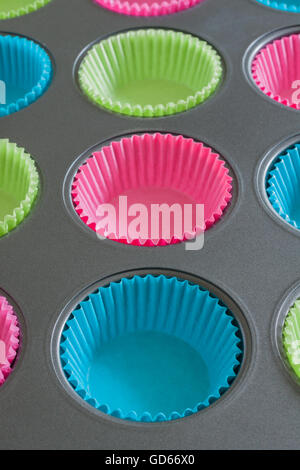 Cake ou muffin tin avec du papier coloré cas utile pour les concepts de cuisson Banque D'Images