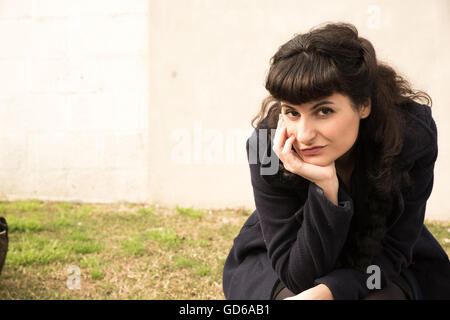 Une fille de style rétro de l'emplacement dans un environnement urbain s'ennuyer. Banque D'Images