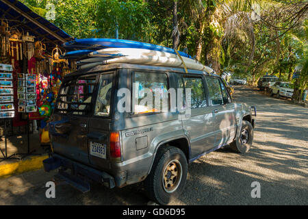 Un camion avec des planches de surf sur le toit du véhicule. Playa Espadilla, Quepos, province de Puntarenas, Costa Rica. Banque D'Images