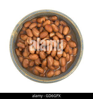 Vue de dessus d'une portion de haricots écossés dans un vieux bol en grès isolé sur un fond blanc. Banque D'Images