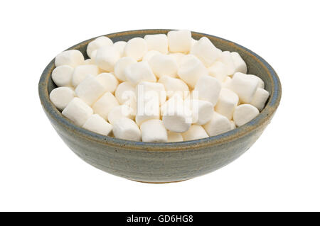 Petits petits guimauves dragées un vieux bol en grès isolé sur un fond blanc. Banque D'Images