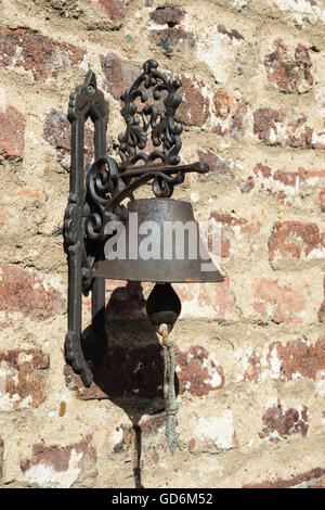 Bell vieux fer placé sur un mur de briques. Banque D'Images