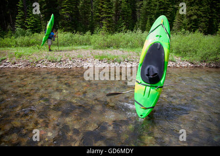 Les kayakistes gué sur un six mile randonnée dans le milieu de la fourche de la rivière Flathead au Montana. Banque D'Images