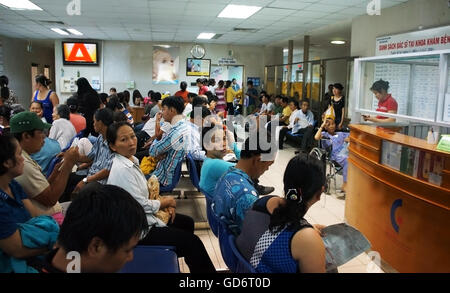 Foule de gens assis et en attendant d'examiner la santé, patient à s'asseoir sur un banc à l'hôpital public Banque D'Images