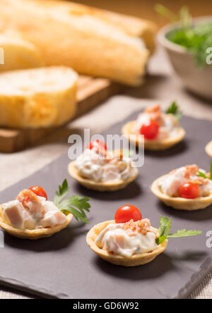 Apéritif avec canapés, salade de poulet crémeux servi sur une plaque en ardoise Banque D'Images