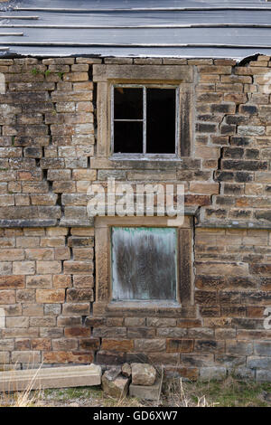 Des fissures dans un mur de pierre d'un chalet ou maison qui est tombée en ruine, England, UK Banque D'Images