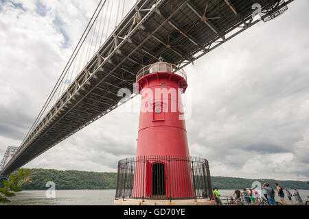 Les visiteurs de la Jeffrey's Hook Lighthouse, connu comme le 'Petit phare rouge' ci-dessous, le pont George Washington à New York lors de leurs portes ouvertes le dimanche, Juillet 10, 2016. Situé dans la région de Fort Washington Park, le phare a été construit en 1880 à l'origine de Sandy Hook, NJ et déplacé à Jeffrey's Hook en 1921. En 1931 lorsque le pont George Washington a été achevé le phare a été mis hors service, mais a été sauvé de la démolition par le biais de la demande publique a commencé par le livre pour enfants "Le Petit phare rouge et le grand pont gris', écrit par Hildegarde Swift et Lynd Ward en 1942. © Richard B. Banque D'Images