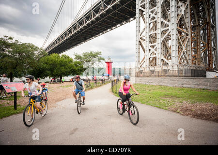 Les visiteurs de la Jeffrey's Hook Lighthouse, connu comme le 'Petit phare rouge' ci-dessous, le pont George Washington à New York lors de leurs portes ouvertes le dimanche, Juillet 10, 2016. Situé dans la région de Fort Washington Park, le phare a été construit en 1880 à l'origine de Sandy Hook, NJ et déplacé à Jeffrey's Hook en 1921. En 1931 lorsque le pont George Washington a été achevé le phare a été mis hors service, mais a été sauvé de la démolition par le biais de la demande publique a commencé par le livre pour enfants "Le Petit phare rouge et le grand pont gris', écrit par Hildegarde Swift et Lynd Ward en 1942. © Richard B. Banque D'Images