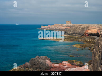 Afficher le long de la côte depuis les falaises à l'est de Playa Blanca, Lanzarote, avec ferry à destination de Fuerteventura dans la distance Banque D'Images
