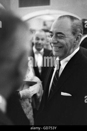 Richard Rodgers parlant avec des invités à un cocktail, 1962. Banque D'Images