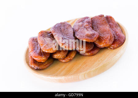 La Thaïlande dessert bananes séchées disposées sur une plaque de bois sur un fond blanc. Banque D'Images