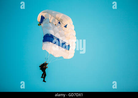 Parachutiste sur parachute coloré au soleil Ciel clair. Passe-temps actif Banque D'Images